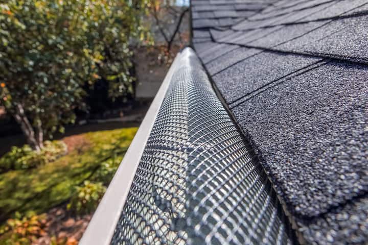 A contractor demonstrating the effectiveness of a gutter guard to a potential client in Myrtle Beach